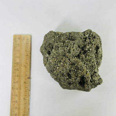 pyrite next to a ruler for size reference