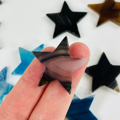 fingers holding up dyed agate star