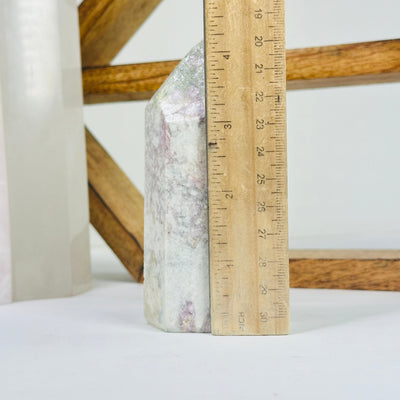 pink tourmaline point next to a ruler for size reference