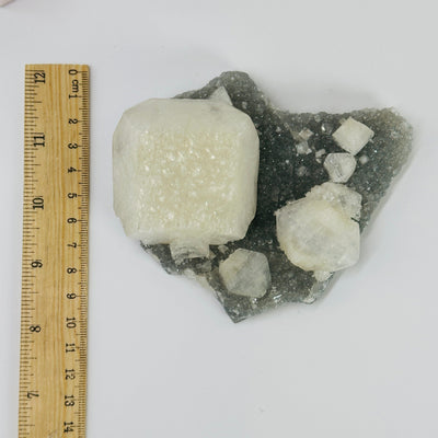 zeolite apophyllite on matrix next to a ruler for size reference