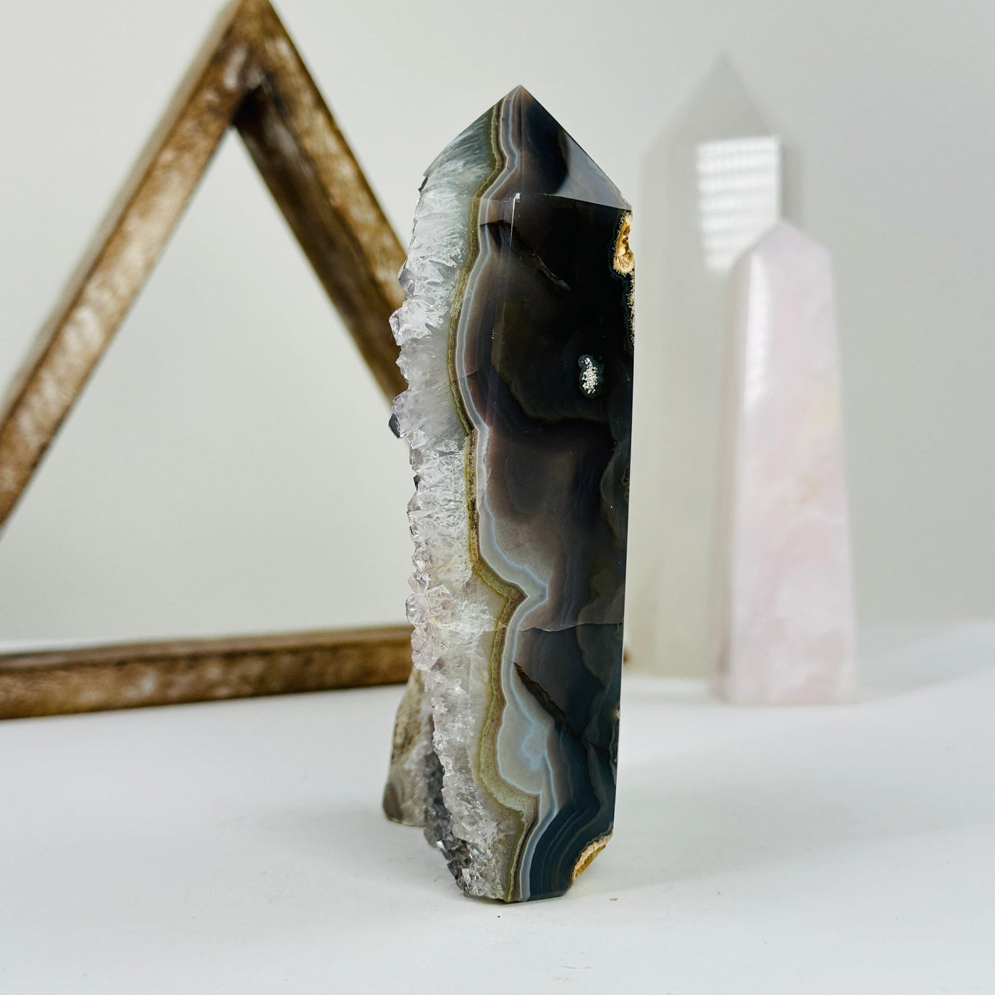 side view of natural agate druzy point with decorations in the background