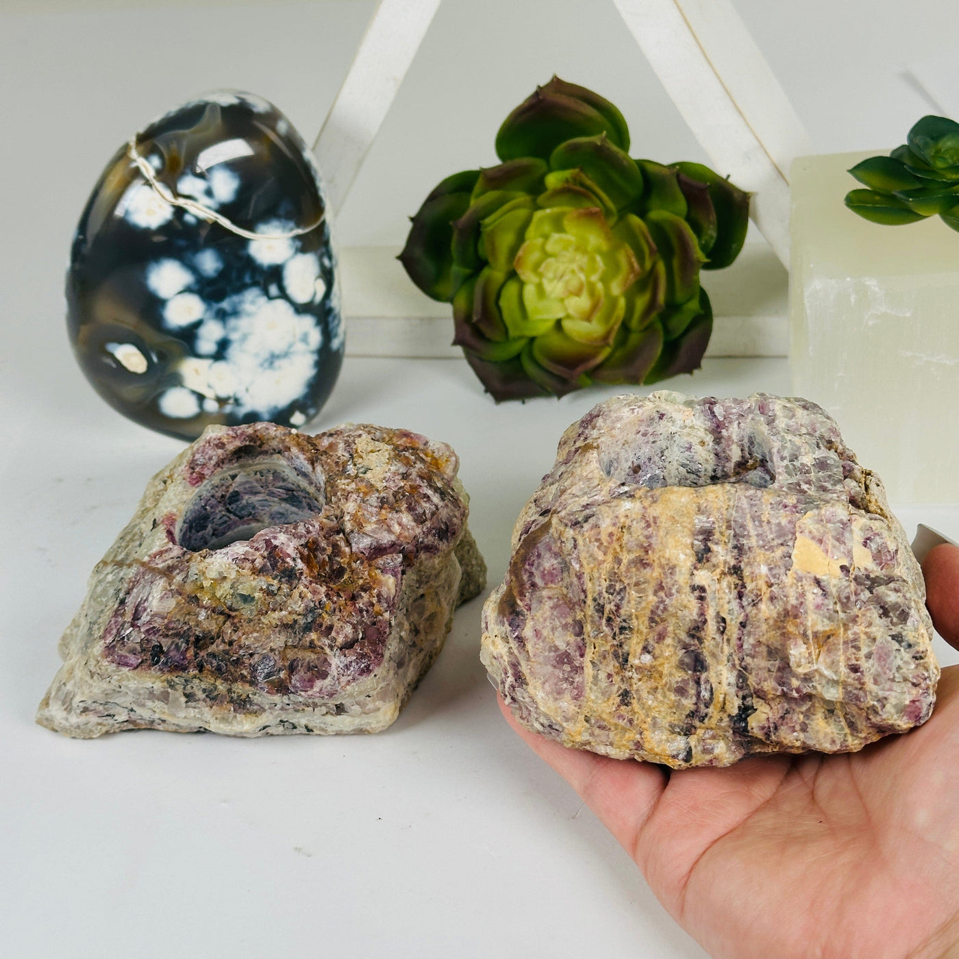 Lepidolite Rough Crystal Candle Holder - You Choose variant 2 in hand for size reference with other variant in the background with props and plants