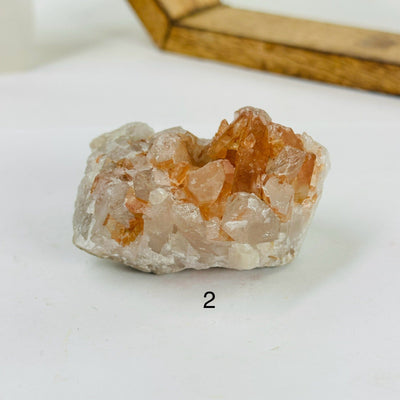 tangerine quartz cluster with decorations in the background