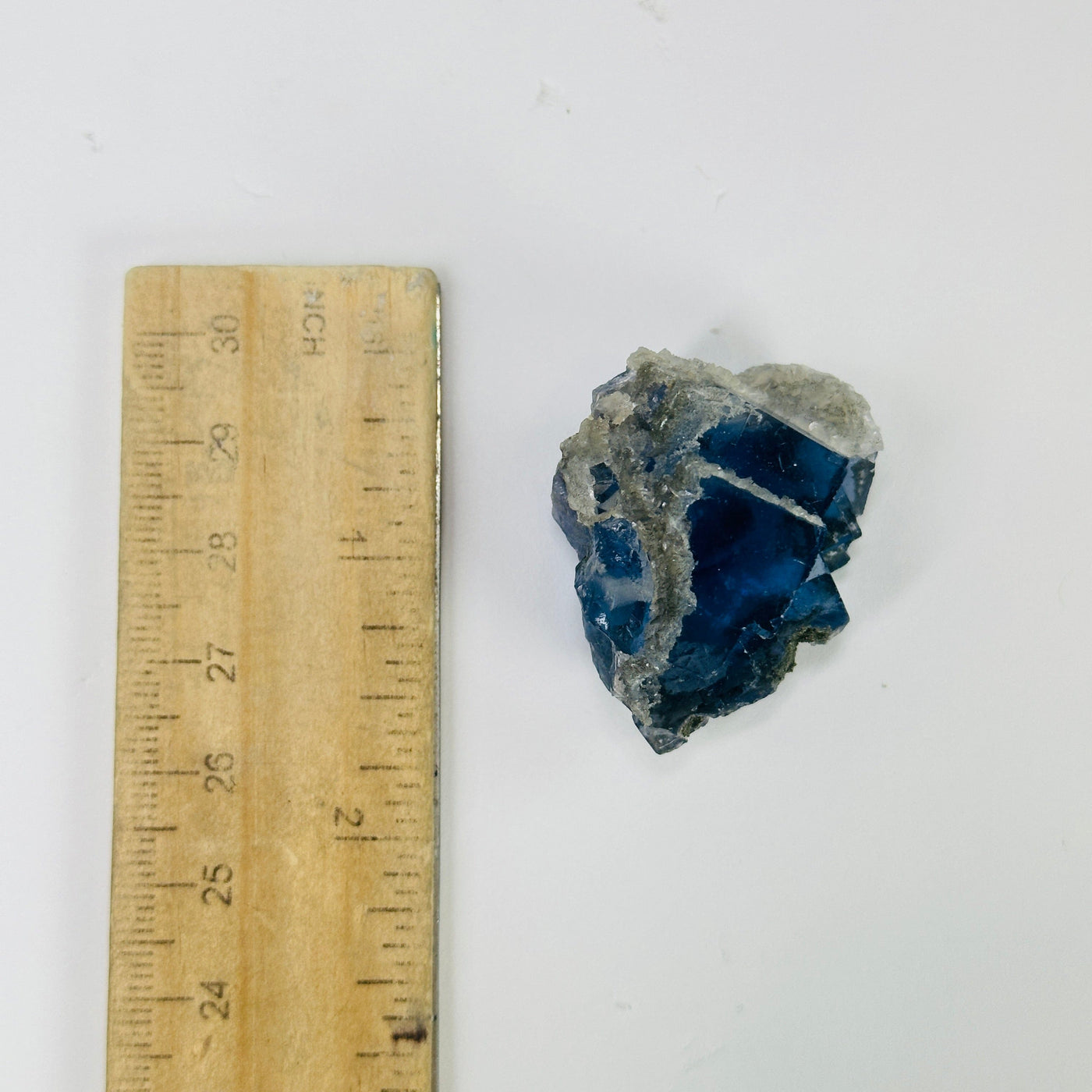 blue fluorite next to a ruler for size reference