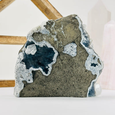 apophyllite cut base with decorations in the background