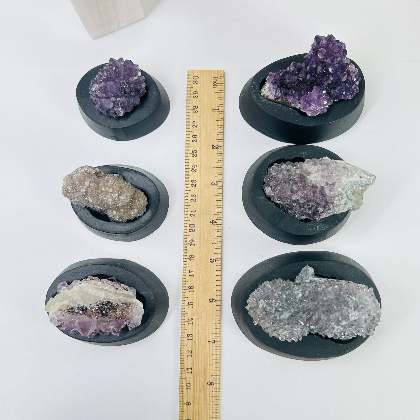 amethyst cluster on stand next to a ruler for size reference