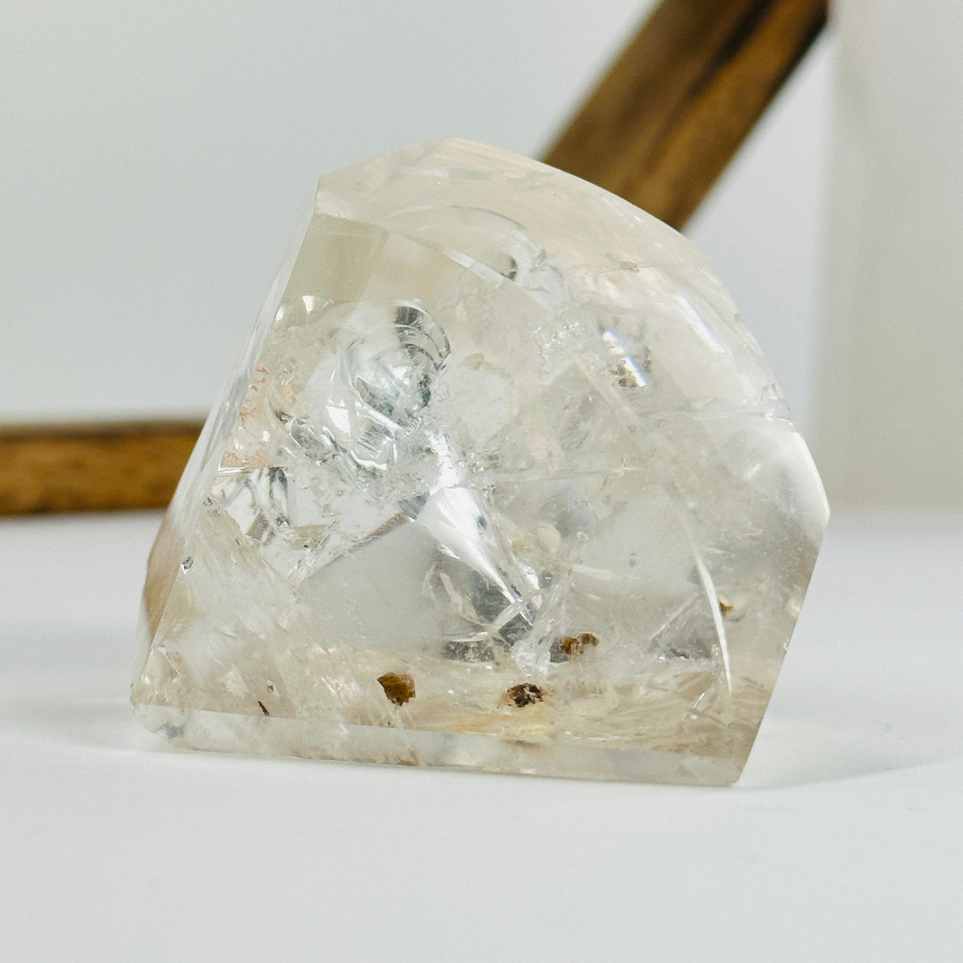 polished crystal quartz with inclusions with decorations in the background