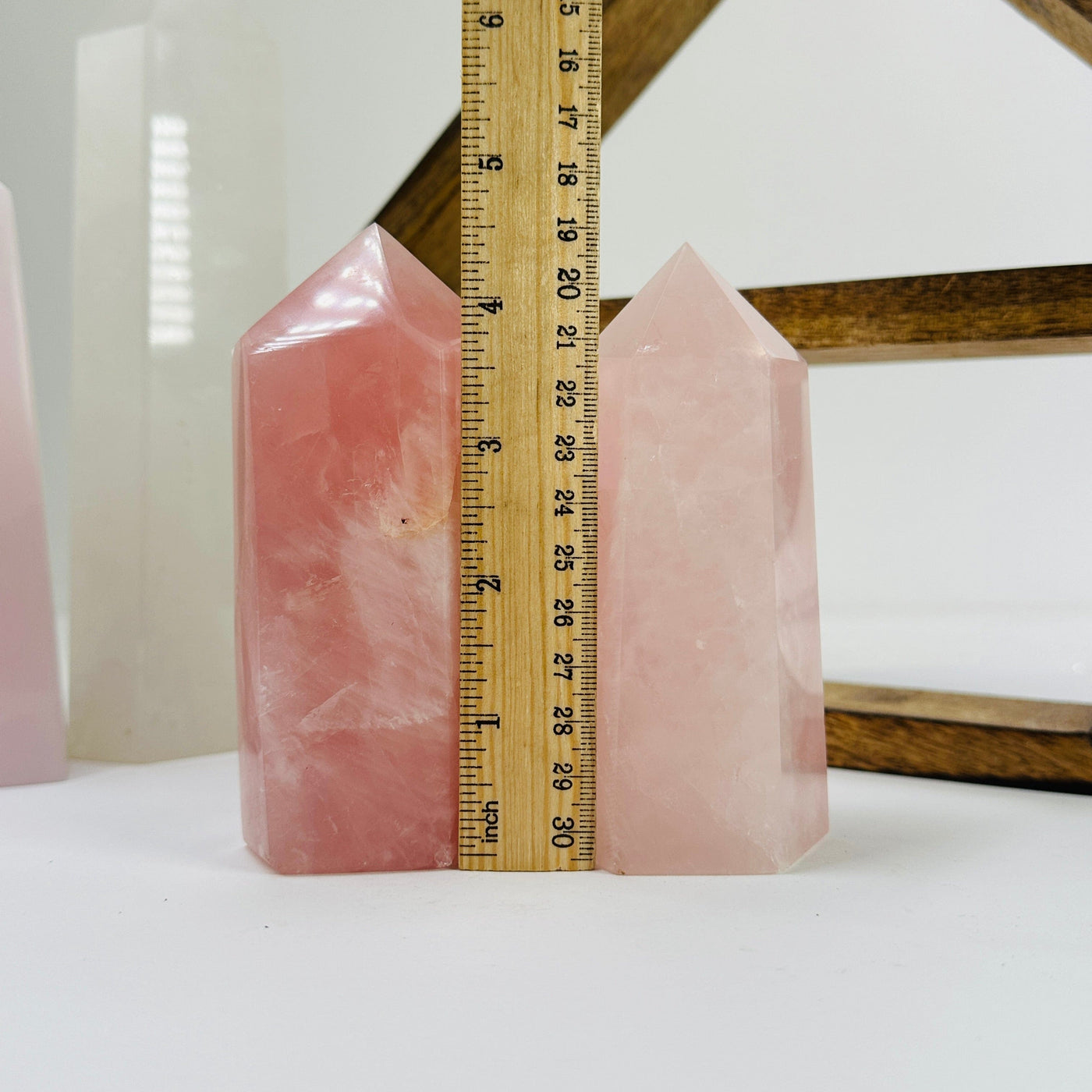 rose quartz point next to a ruler for size reference