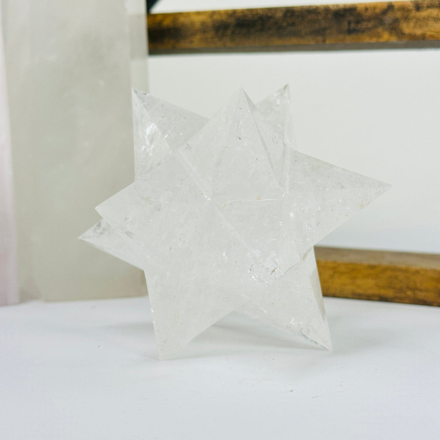 crystal quartz merkaba with decorations in the background