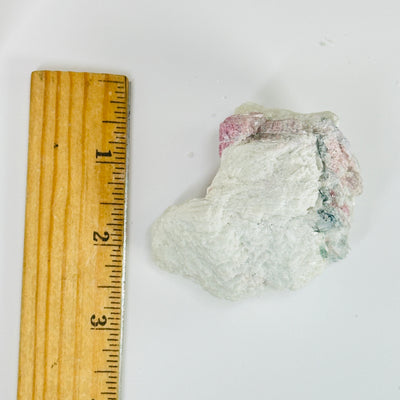 tourmaline next to a ruler for size reference