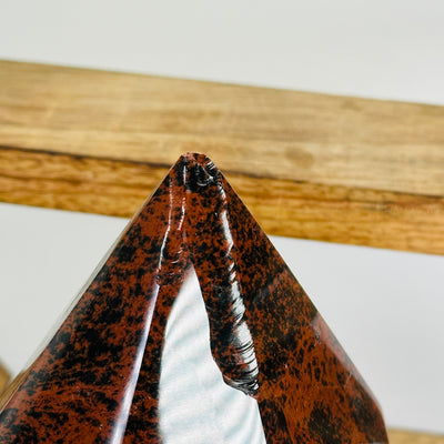 mahogany obsidian point with decorations in the background