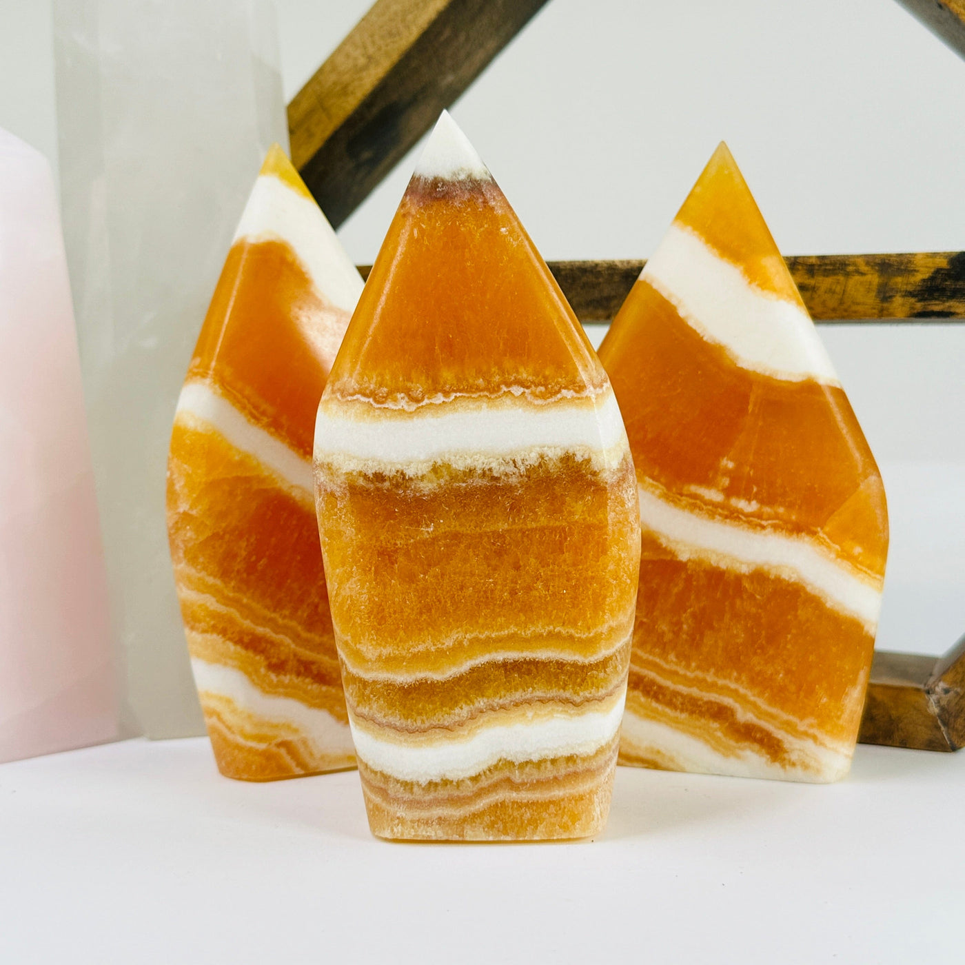 BANDED CALCITE POint with decorations in the background