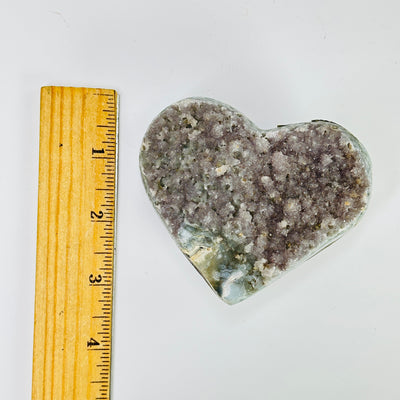 amethyst heart next to a ruler for size reference