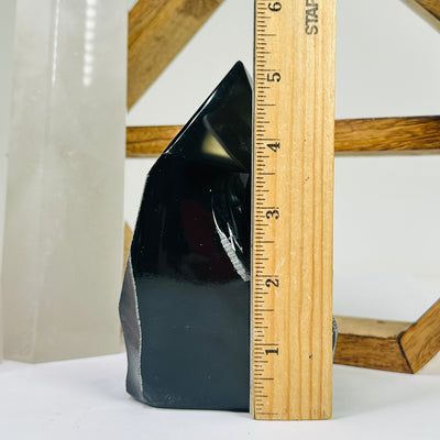 obsidian point next to a ruler for size reference