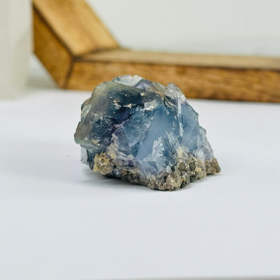 Blue fluorite crystal with decorations in the background