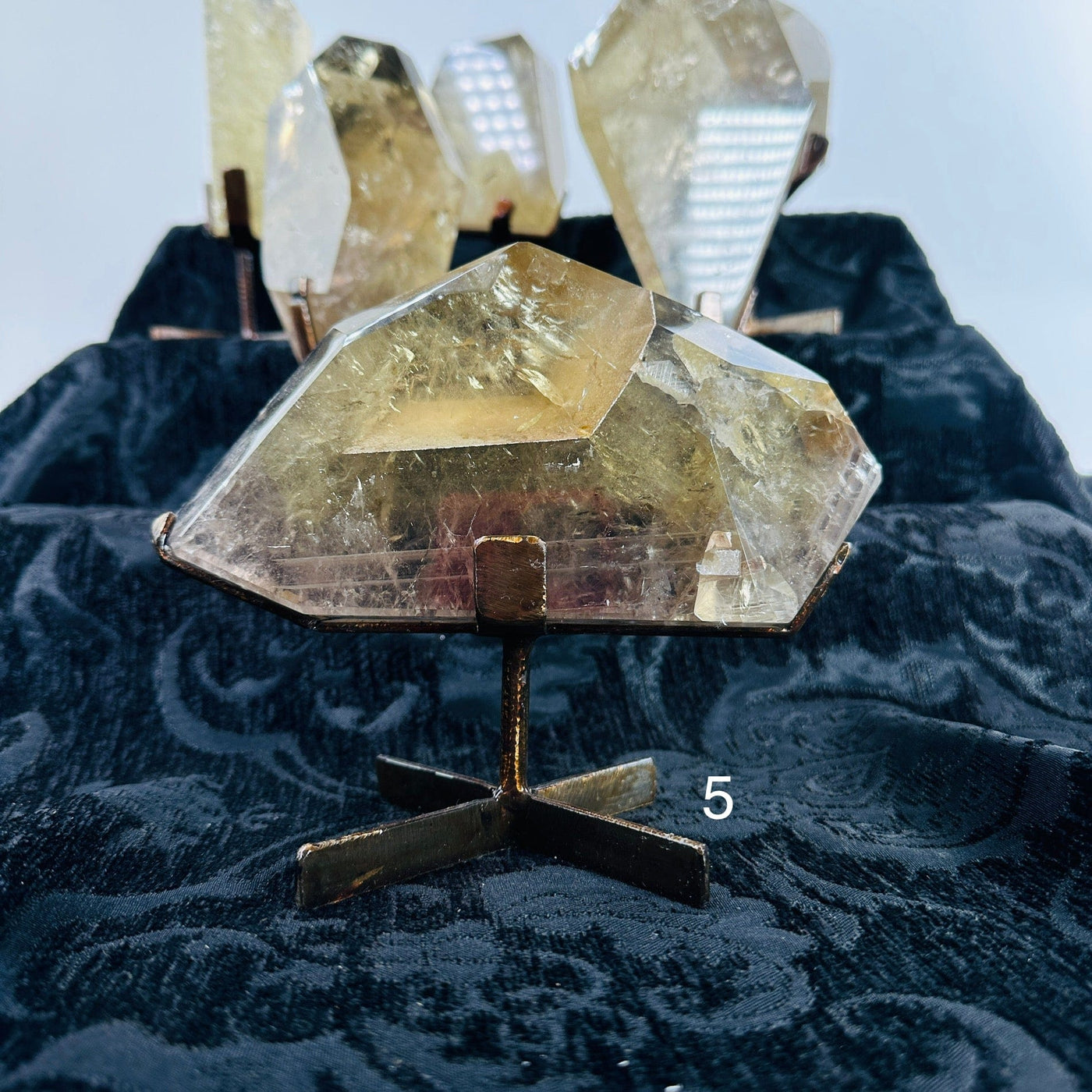 natural citrine on metal stand with decorations in the background