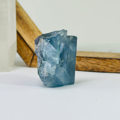 Blue fluorite crystal with decorations in the background