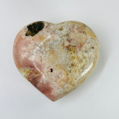pink amethyst heart with decorations in the background