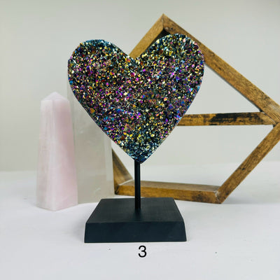 titanium coated heart on stand with decorations in the background