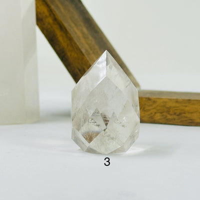 crystal quartz point with decorations in the background