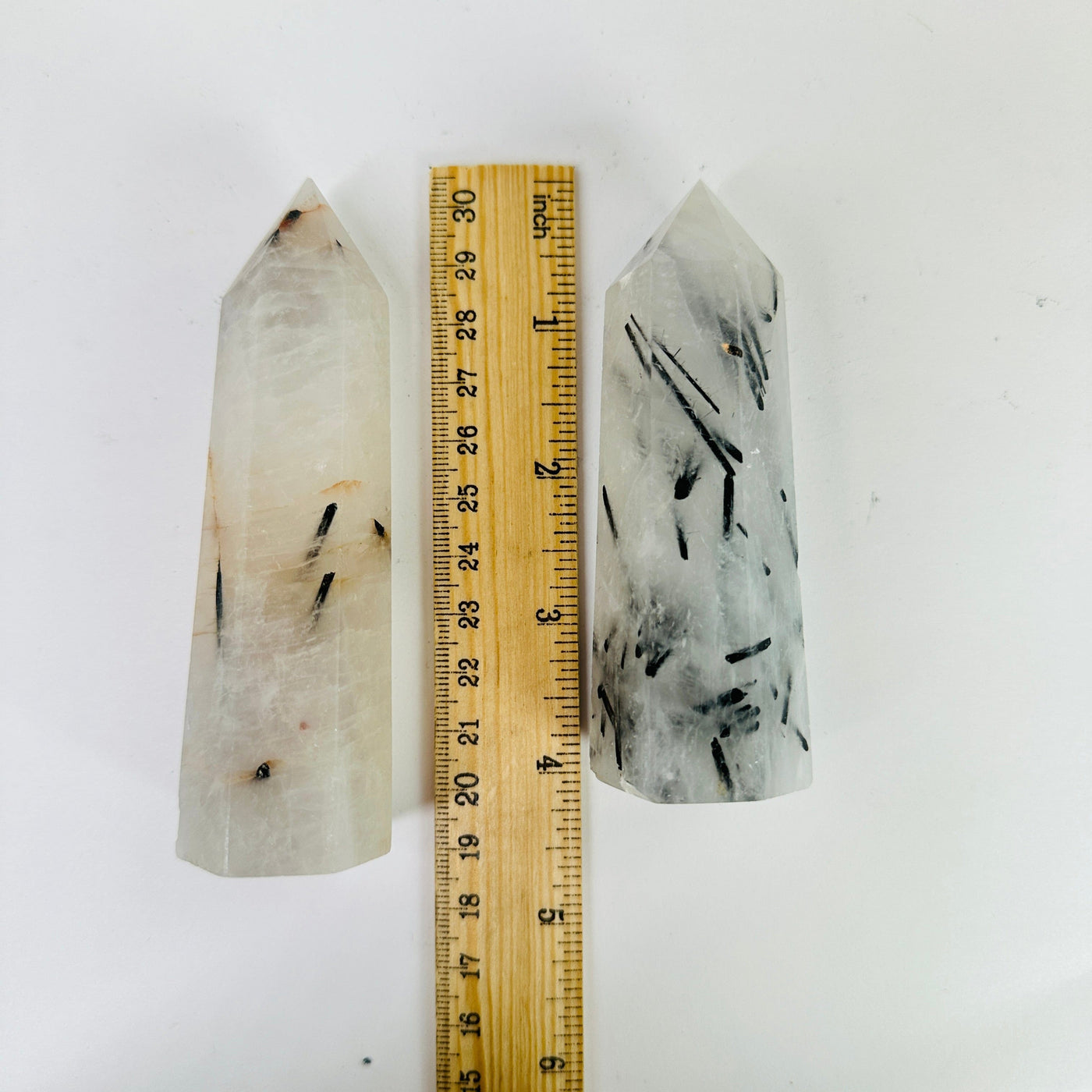 rutilated quartz point next to a ruler for size reference