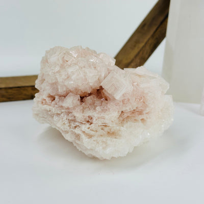 pink halite cluster with decorations in the background