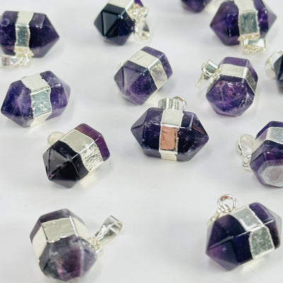 amethyst pendants scattered on white background