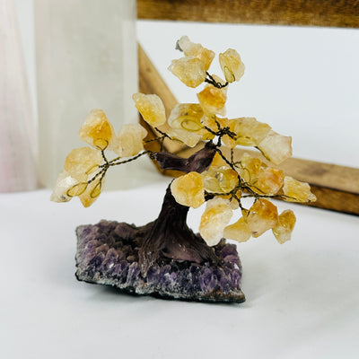 citrine tree of amethyst base with decorations in the background