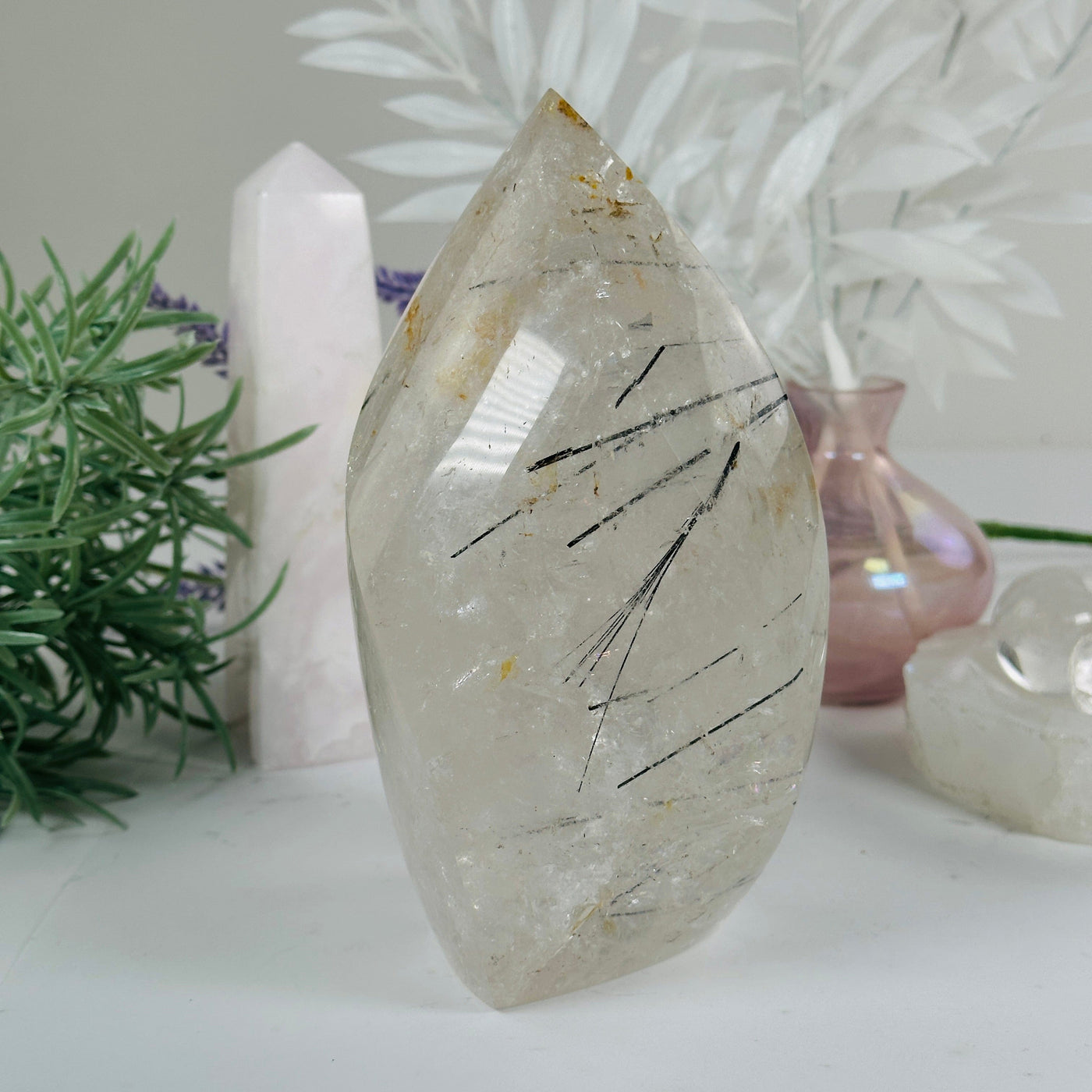 Golden Healer Quartz with Black Tourmaline - Crystal Flame Point Cut Base - One-of-a-Kind #3 front view with props and plants in the background