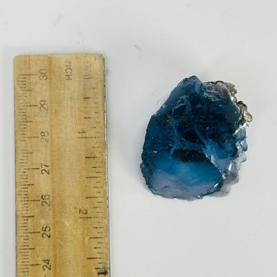 blue fluorite next to a ruler for size reference