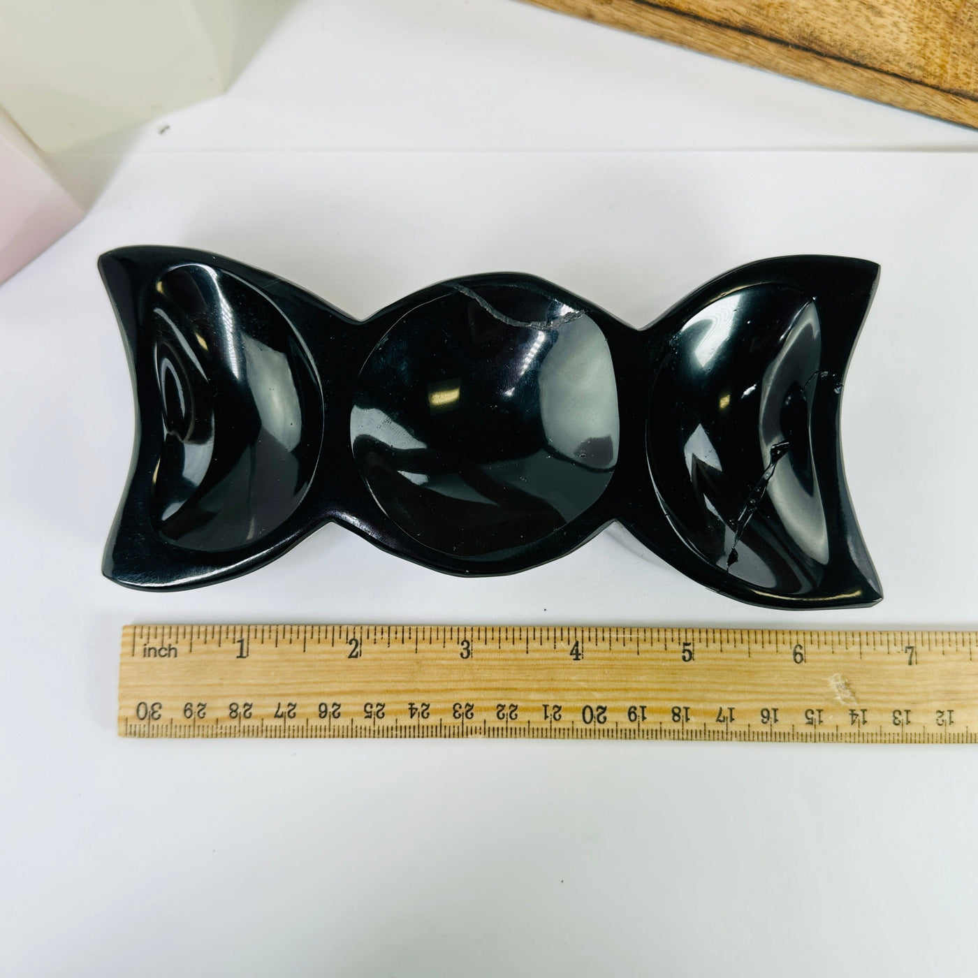 obsidian moon bowl next to a ruler for size reference