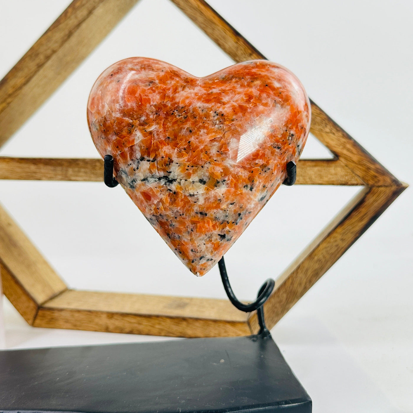 Orchid calcite hearts on stand with decorations in the background