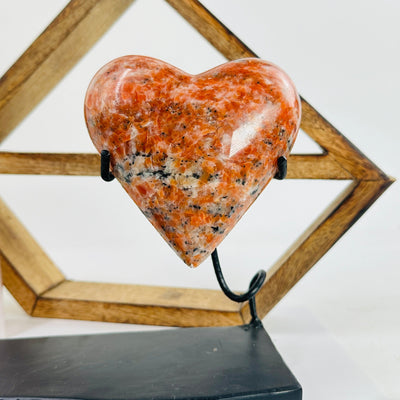 Orchid calcite hearts on stand with decorations in the background