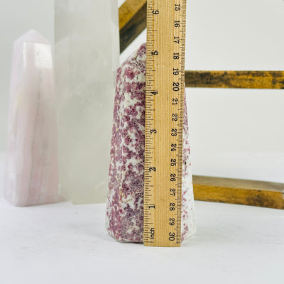 pink tourmaline point next to a ruler for size reference