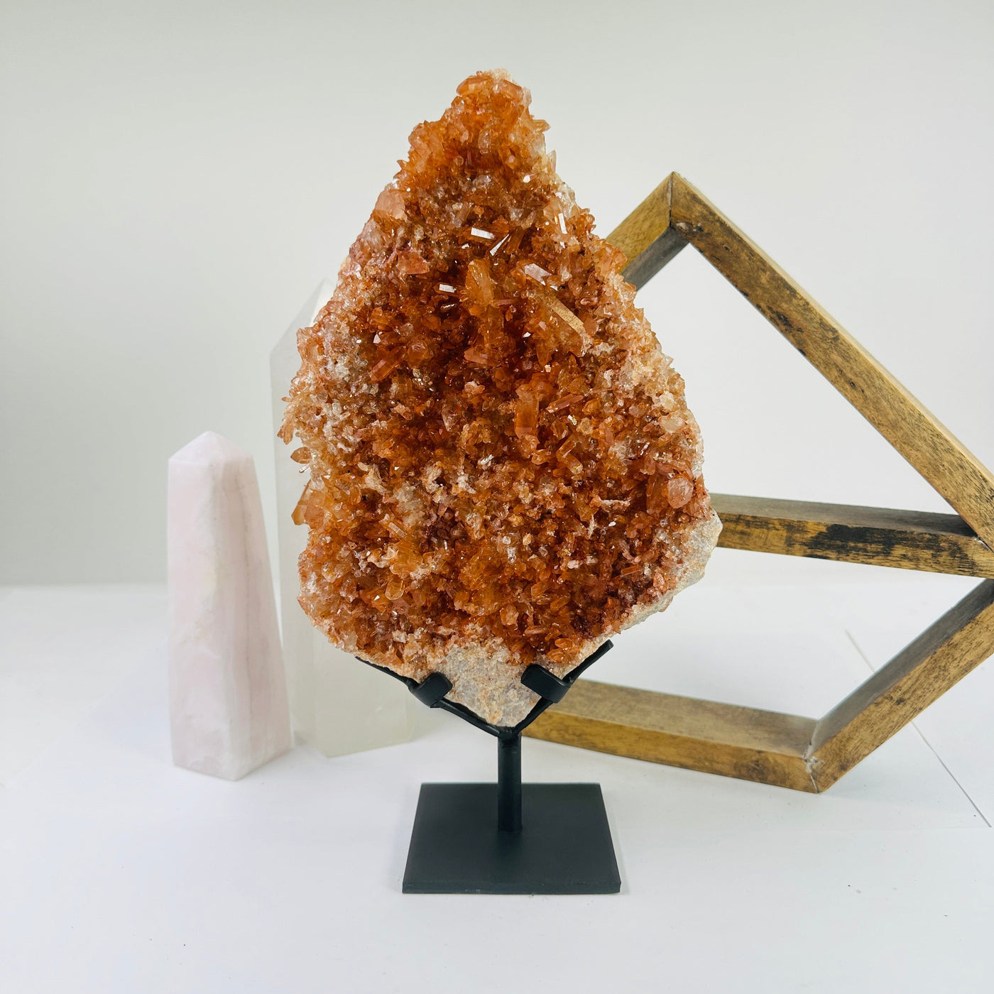 tangerine quartz on stand with decorations in the background