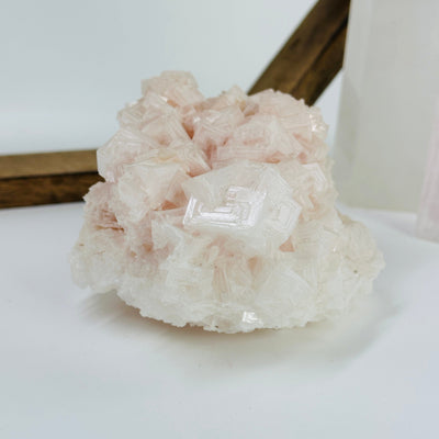 pink halite cluster with decorations in the background