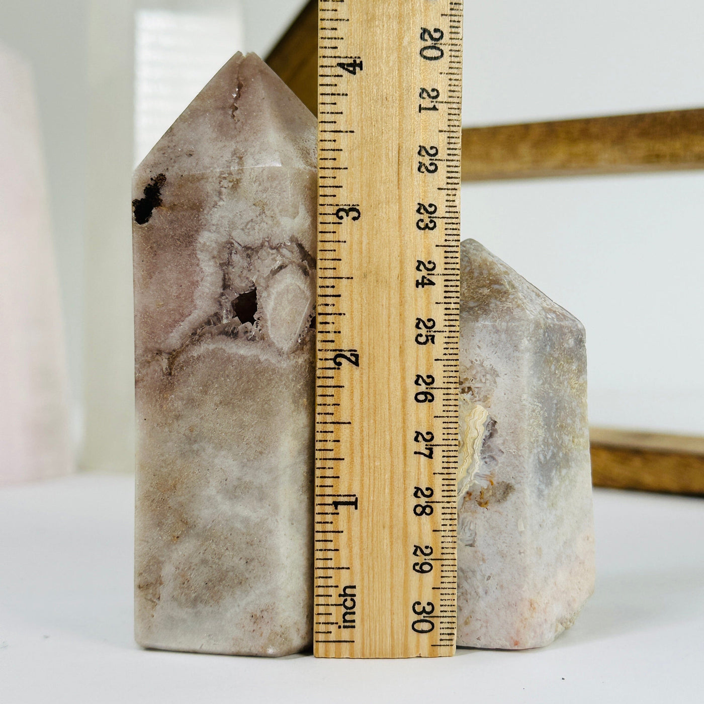 pink amethyst point next to a ruler for size reference