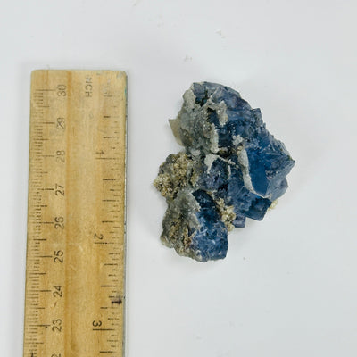 blue fluorite next to a ruler for size reference