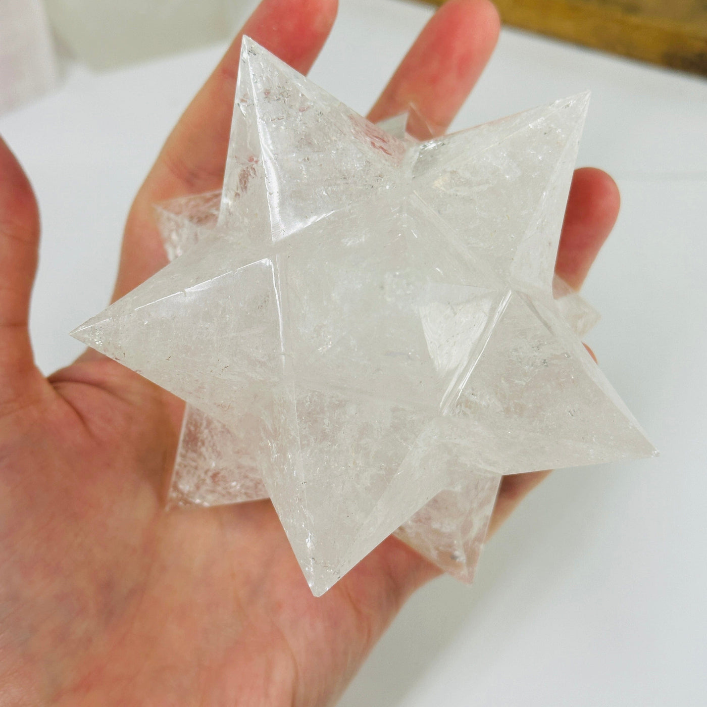 crystal quartz merkaba with decorations in the background