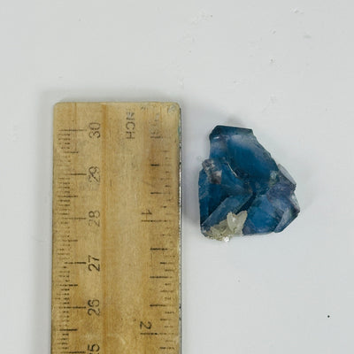 blue fluorite next to a ruler for size reference