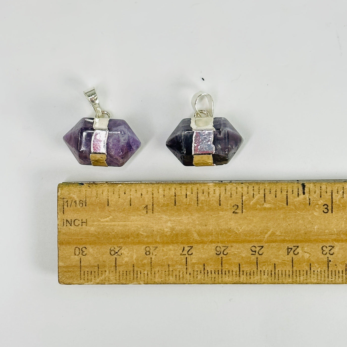 amethyst pendants next to a ruler for size reference