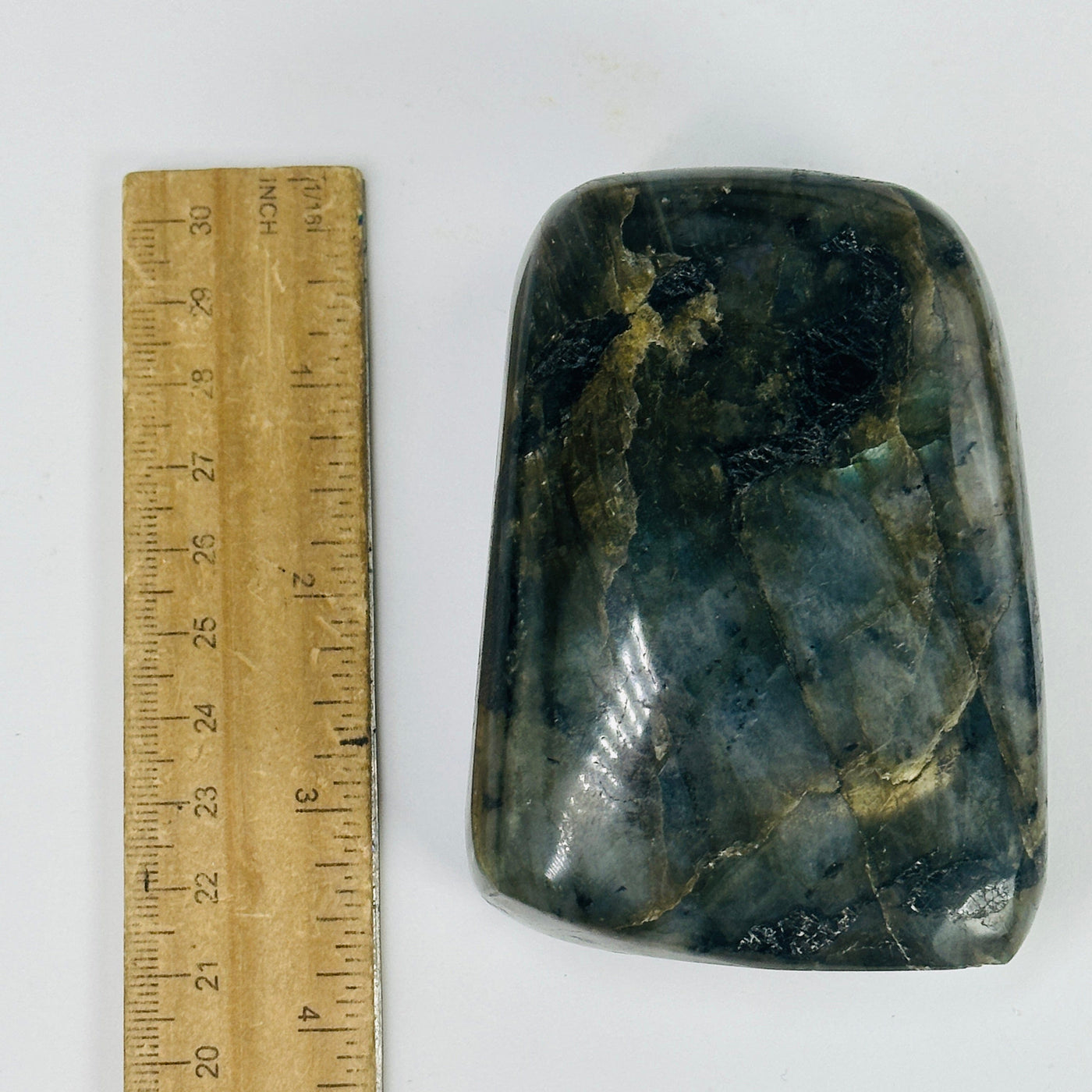 labradorite next to a ruler for size reference
