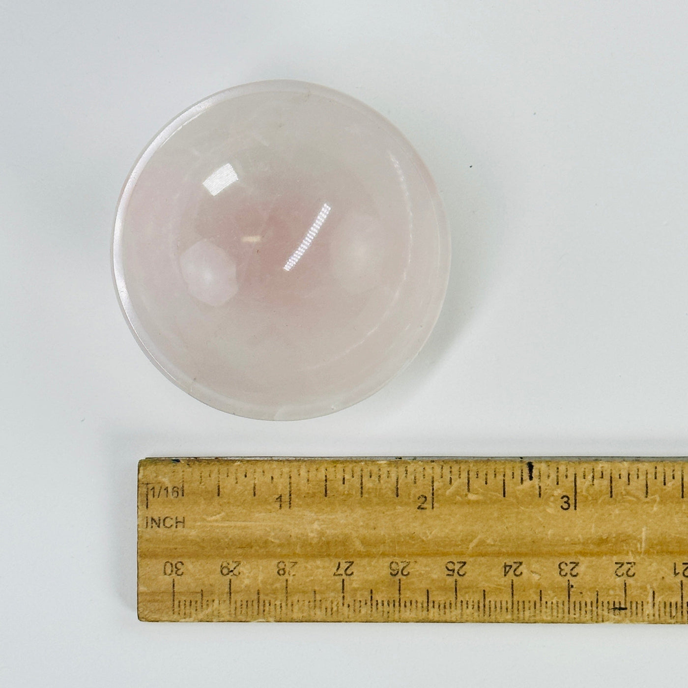 mini rose quartz bowl next to a ruler for size reference