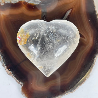 Crystal Quartz Heart with Natural Inclusions - One-of-a-Kind on agate slice top view
