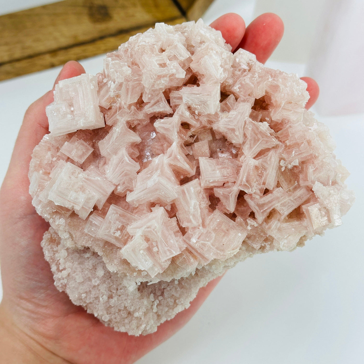 Pink halite cluster with decorations in the background