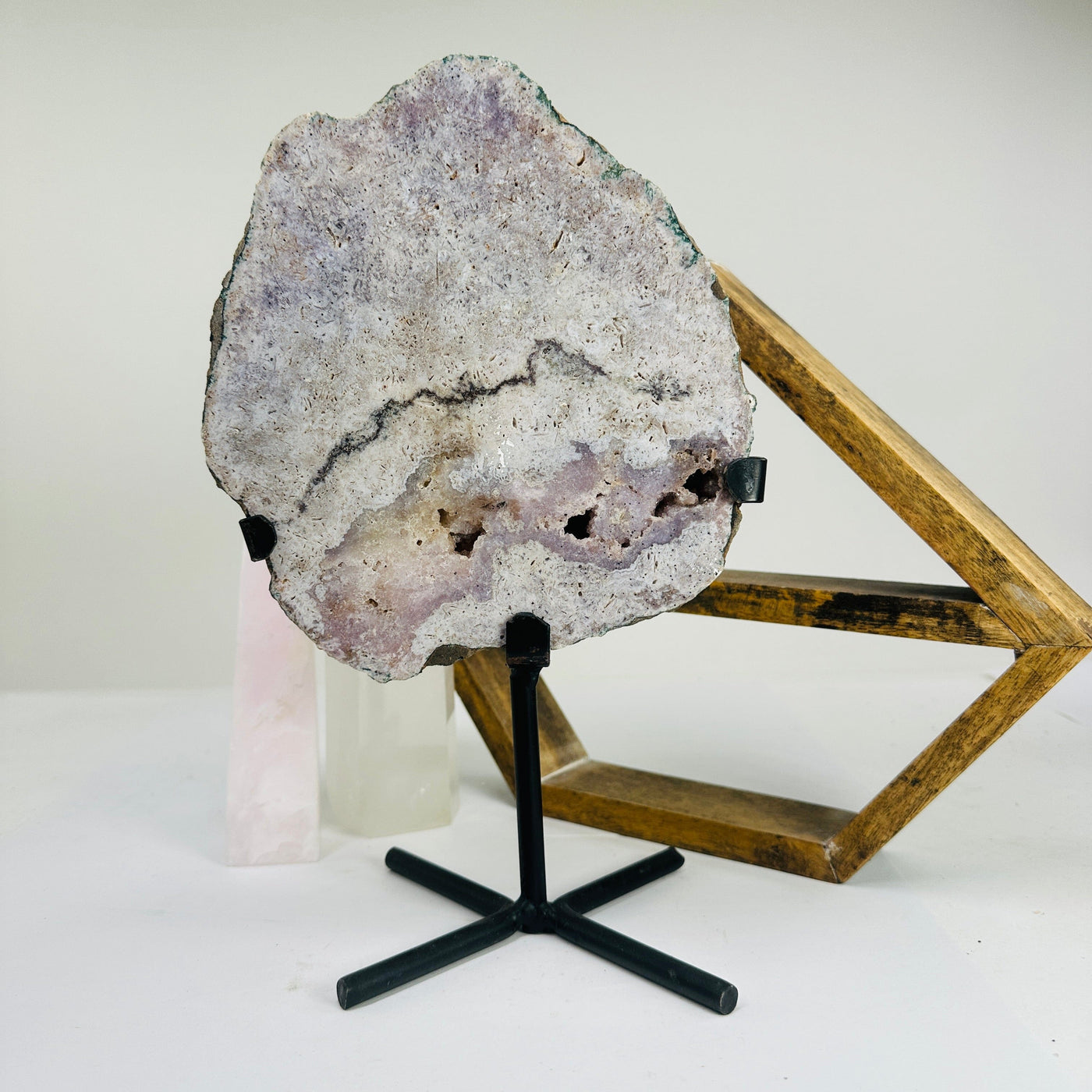 pink amethyst on metal stand with decorations in the background