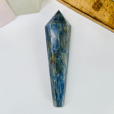 kyanite point with decorations in the background