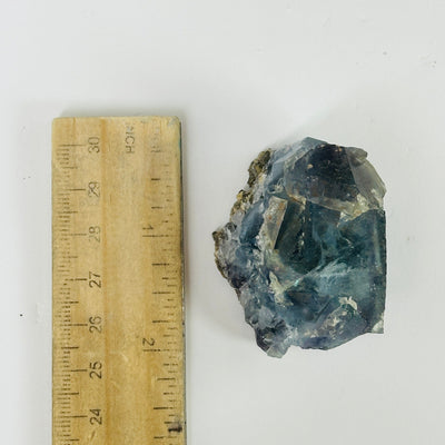 Blue fluorite crystal next to a ruler for size reference