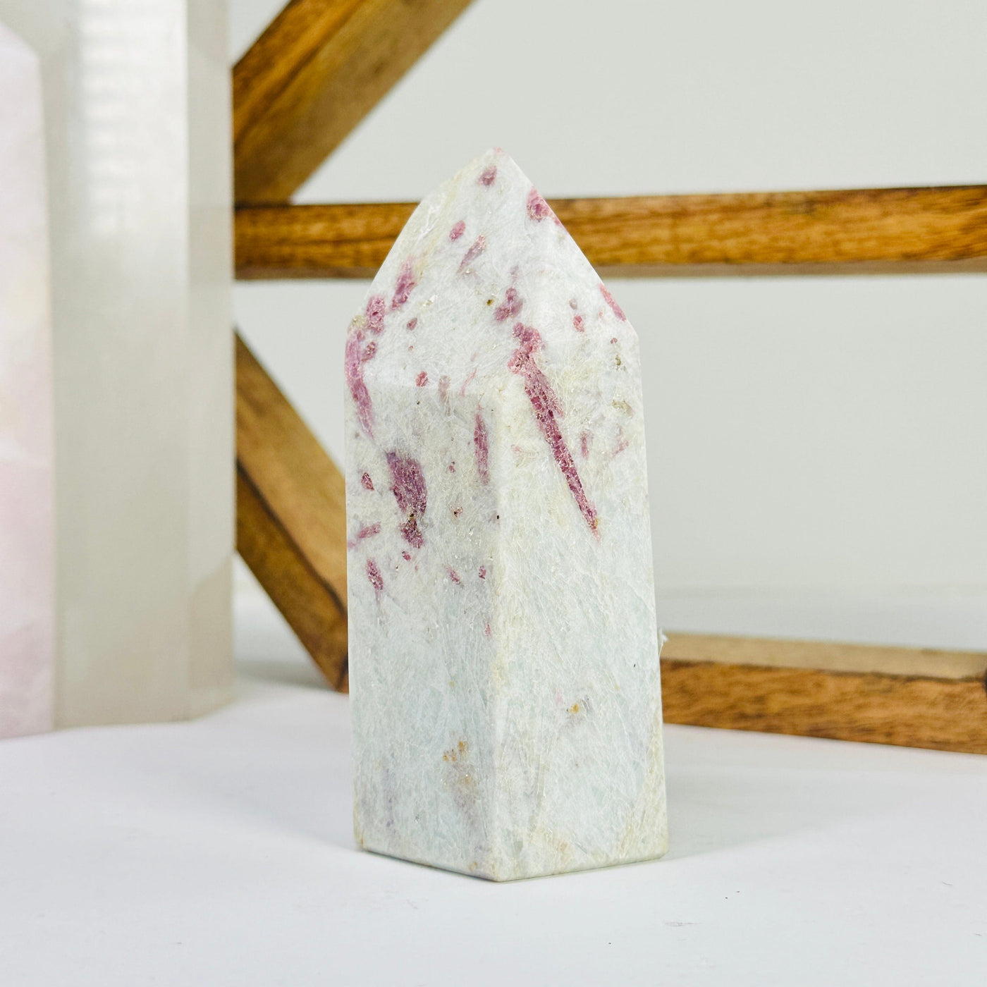 pink tourmaline point with decorations in the background