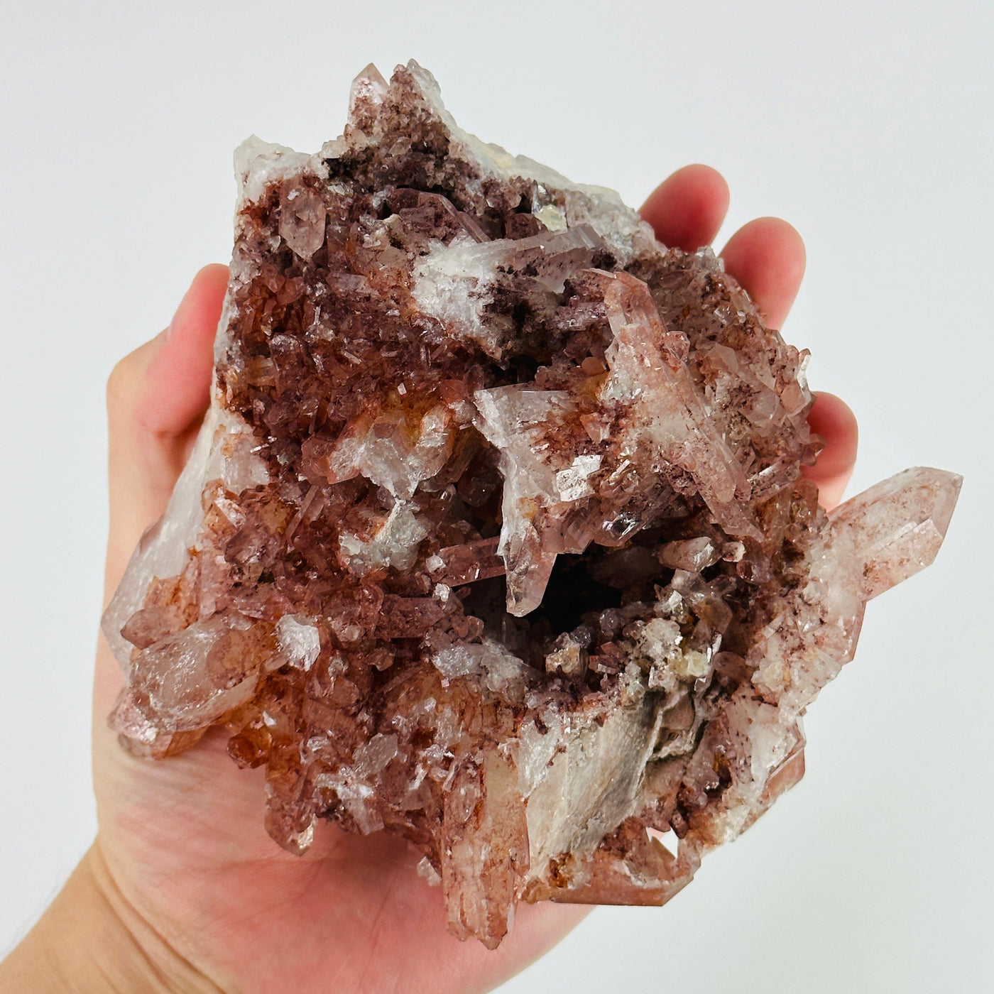 hand holding up lithium quartz cluster showing the bottom side